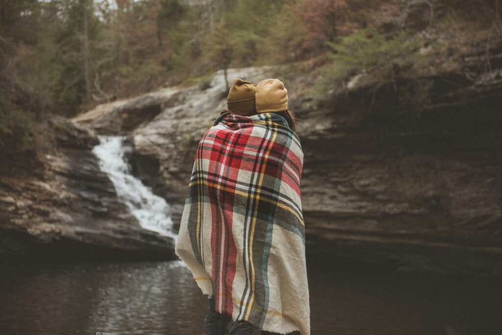 couple standing outside with a blanket around them