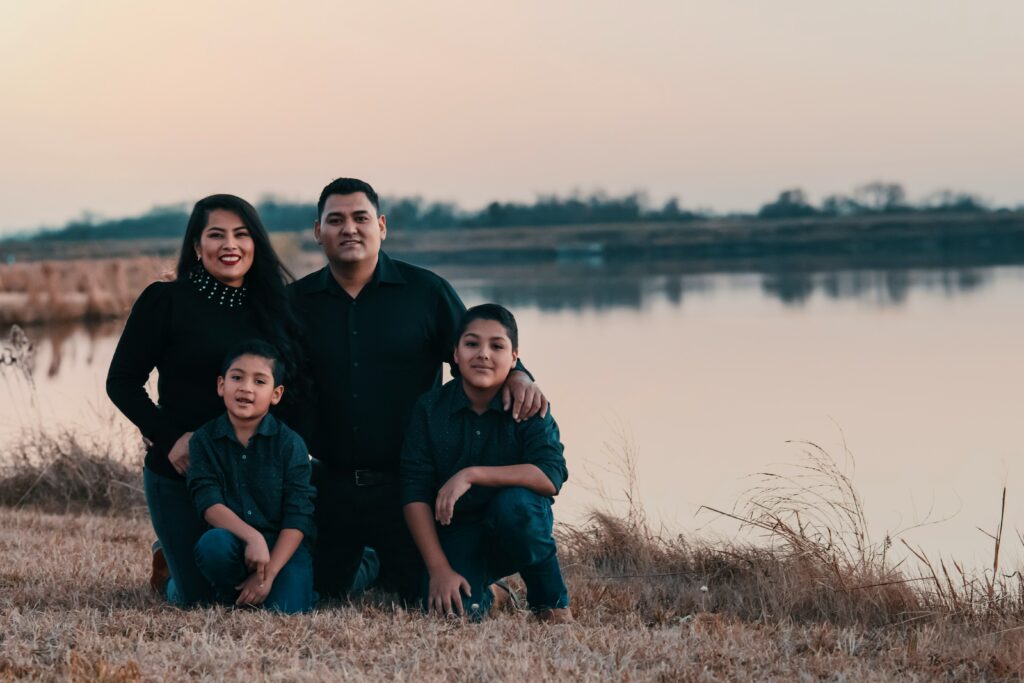 a family portrait at a lake with a family of 4 having completed family counseling.