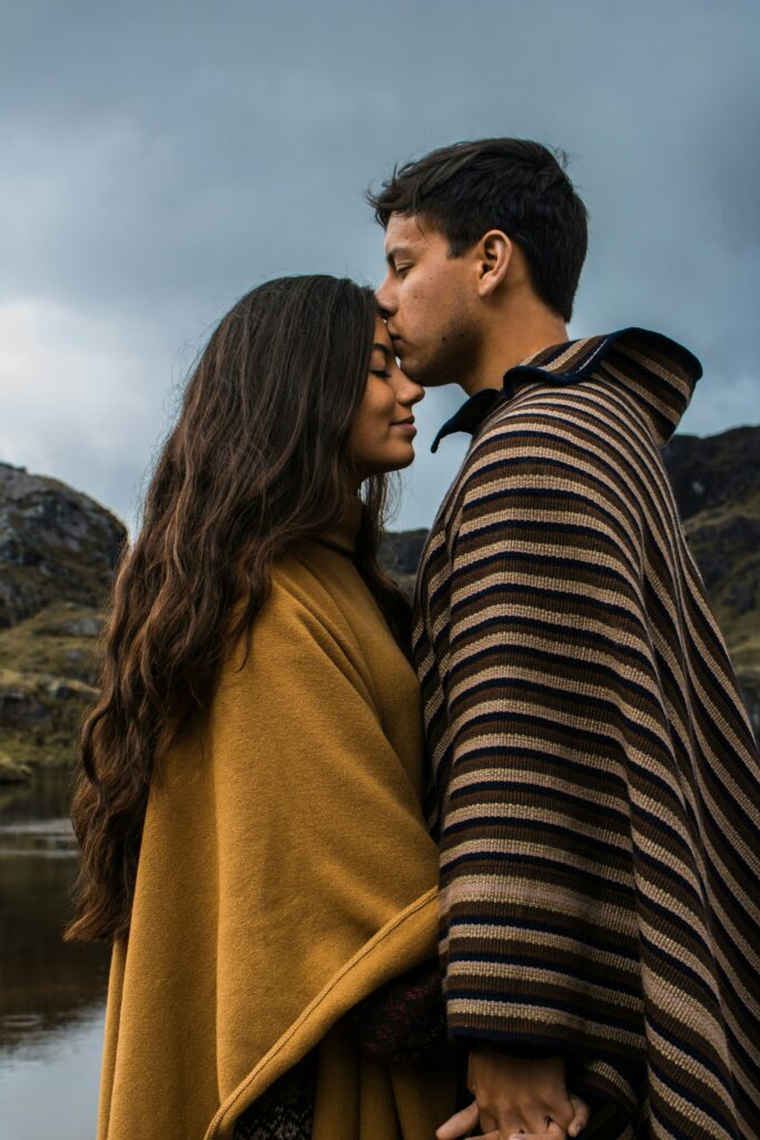 couple standing outside the man is kissing the woman's head after couples therapy