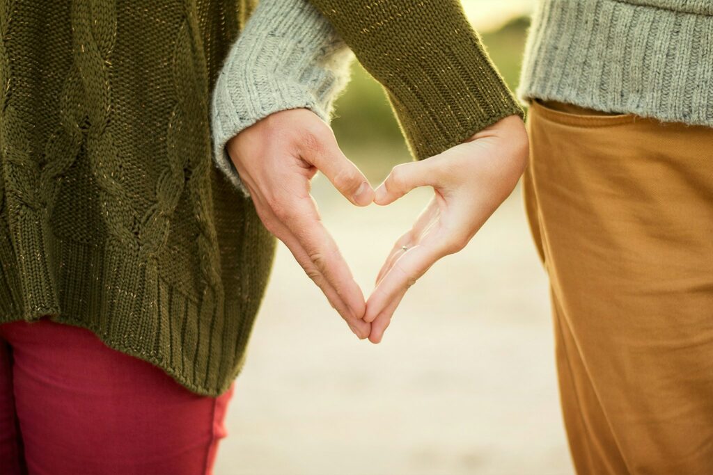 a couples hands at their side forming a heart together signifying growth through therapy