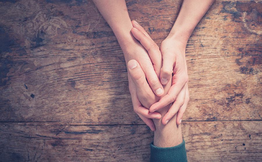 Alt Tag: Hands holding across a table showing support for Healing from Trauma as part of Individual Therapy